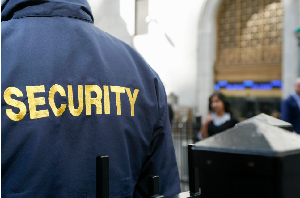 A man in a blue jacket with the word security on it.